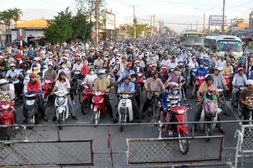 Bild: Wartende Mopeds vor dem Bahnübergang in Ho-Chi-Minh-Stadt