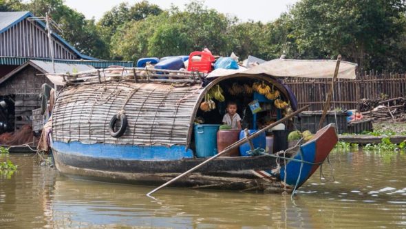 Händler auf einem Boot bei den schwimmenden Dörfern in Kambodscha