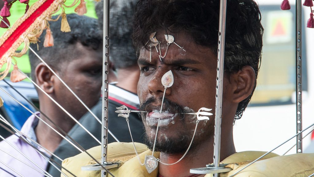 Junger Mann mit durchstochener Zunge und Wangen bei Thaipusam in Singapur (Little India)