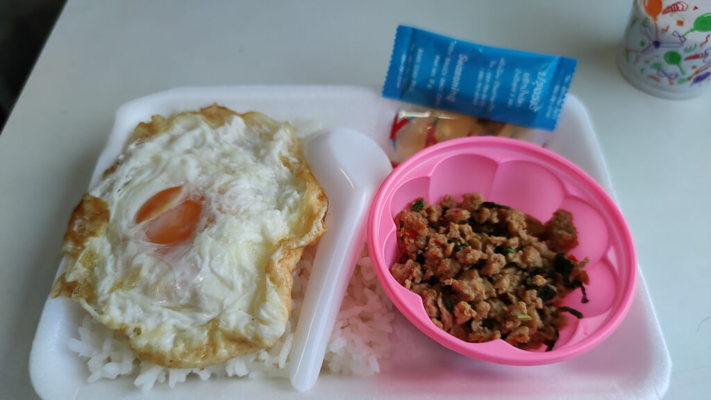 Pad Kra Pao zum Frühstück von einem Händler in einem Zug in Thailand.